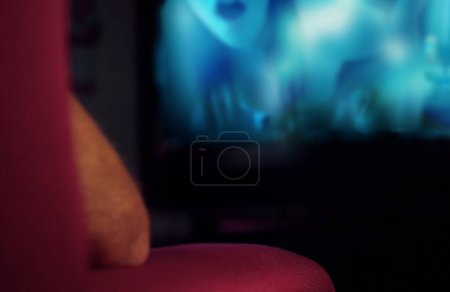 Téléchargez les photos : Homme assis le dos tourné sur un canapé regardant un film pour adulte. - en image libre de droit