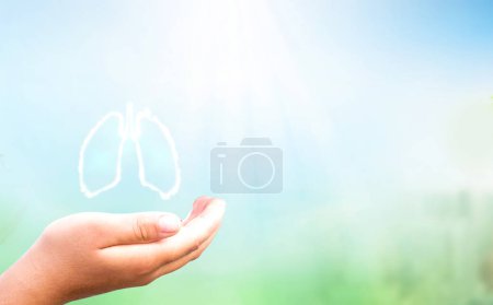 Téléchargez les photos : Main tenant la forme du poumon humain blanc sur le coucher du soleil PM2.5 fond de la ville - en image libre de droit