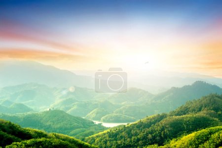 Téléchargez les photos : Forêt sur la montagne lumière tomber sur la clairière sur les montagnes au coucher du soleil ciel arrière-plan - en image libre de droit