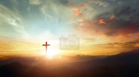 Téléchargez les photos : Le symbole crucifix de Jésus sur le fond du ciel couchant de la montagne - en image libre de droit