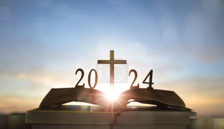 Téléchargez les photos : 2024 nouvelle année et croix de Jésus-Christ sur la bible sainte ouverte avec fond de lever de soleil - en image libre de droit