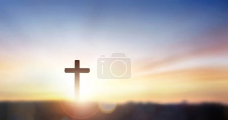 Christliches Kreuz auf einem Hügel im Freien bei Sonnenaufgang