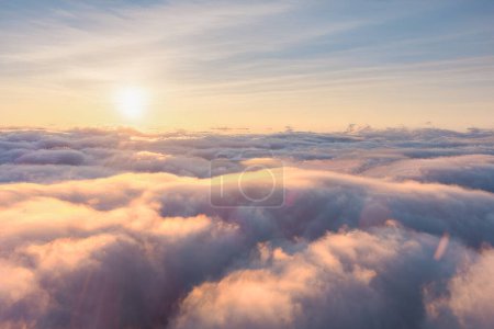 The sun is peeking through the billowy cumulus clouds in the atmospheric phenomenon of the sky, creating a beautiful landscape against the horizon
