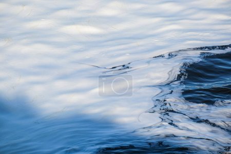 Ruhige und ruhige, sonnenbeschienene, plätschernde Wassertextur mit abstrakten natürlichen Mustern und ruhigen Wasserdetails