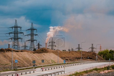 An industrial zone with power lines and smoke emissions from a factory. The scene emphasizes the environmental impact of industrial activities, highlighting pollution and infrastructure.