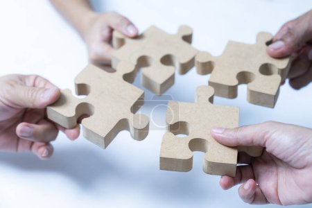 Photo for Hands helping to put together a jigsaw puzzle - Royalty Free Image