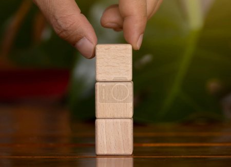 Photo for Hand picking up an empty wooden block stack up vertically - Royalty Free Image