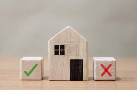Deciding to buy a house with a wooden model on the table Home and property management concept