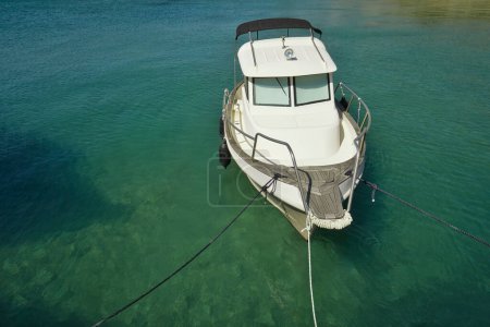 Téléchargez les photos : Un petit bateau avec cabine et ancres de toit ouvrant dans le port - en image libre de droit