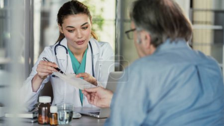Téléchargez les photos : Doctor explains prescription to patient - en image libre de droit