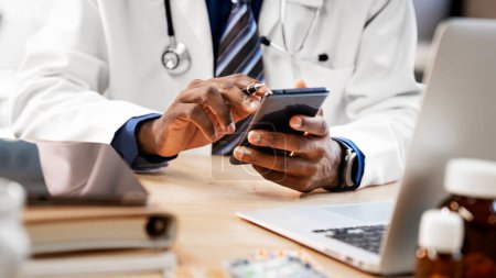 Téléchargez les photos : Médecin utilisant le téléphone portable dans la clinique - en image libre de droit
