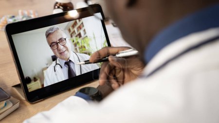 Téléchargez les photos : Médecin parle au médecin sur ordinateur - en image libre de droit