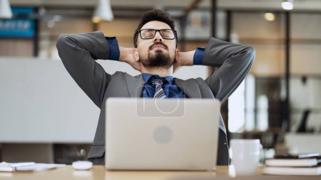 Téléchargez les photos : Homme d'affaires fatigué s'étirant dans le bureau - en image libre de droit