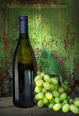Foto de Bodegón con botella de vino blanco y uva de rama sobre fondo de pared con textura de pintura vieja - Imagen libre de derechos