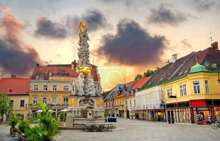 Téléchargez les photos : Paysage urbain avec colonne de la Trinité (colonne de la peste) sur la place principale à Baden près de Vienne. Autriche - en image libre de droit