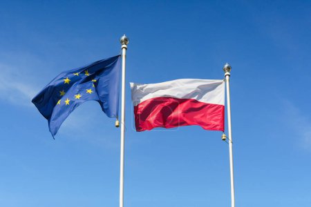 Téléchargez les photos : Drapeau de la Pologne et de l'Union européenne contre le ciel. Concept UE et Pologne. Photo de haute qualité - en image libre de droit