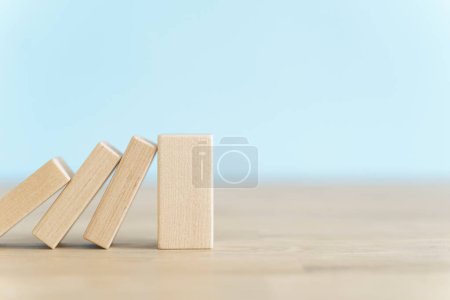 Téléchargez les photos : Chute de cubes domino en bois. Assurance, entreprise, risque, concept de gestion. Photo de haute qualité - en image libre de droit