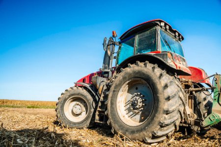Traktor auf dem Feld. Landmaschinen. Landwirtschaftlicher Traktor bei der Boden- und Feldbearbeitung nach der Ernte. Hochwertiges Foto