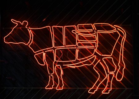 Leuchtreklame einer Kuh, die Rindfleisch in Fleischteile zerlegt. Hochwertiges Foto