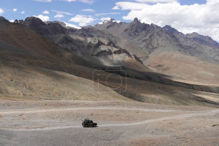 Foto de Ladakh, India - August 24th, 2022: Offroad vehicle goes on the mountain on empty road of ladakh in india - Imagen libre de derechos