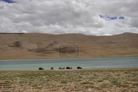 Foto de Ladakh, India - August 24th, 2022: SUV Car 4x4 In Mountains ove a Beautiful Lake in Ladakh, Tso Moriri Lake - Imagen libre de derechos