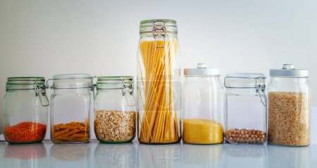 Téléchargez les photos : Différentes céréales dans des bocaux en verre sur fond blanc, saine alimentation et concept de régime alimentaire - en image libre de droit