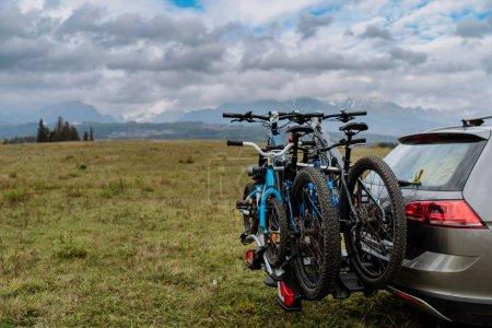 Photo for Car with bike racks and bicycles at an autumn meadow. - Royalty Free Image