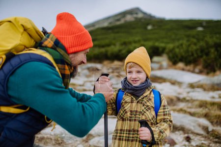 Téléchargez les photos : Père et son petit fils marchant ensemble dans les montagnes. - en image libre de droit