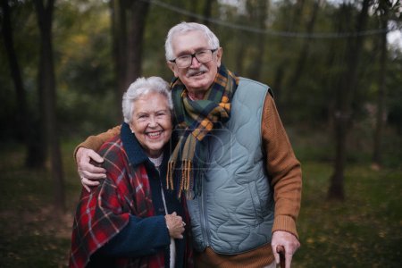 Portrait of senior couple walking together in autumn nature.