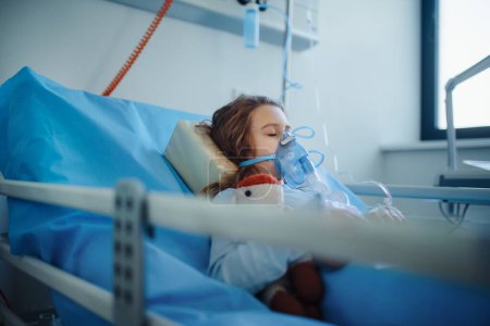 Foto de Primer plano de la niña con enfermedad infecciosa que yace en la habitación del hospital. - Imagen libre de derechos