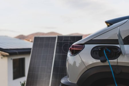 Téléchargez les photos : Chargement de voiture électrique à partir de la centrale photovoltaïque domestique, concept de transport durable et économique. - en image libre de droit