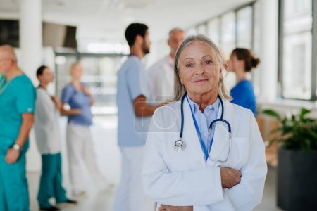 Photo for Portrait of elderly doctor at a hospital corridor. - Royalty Free Image