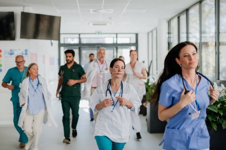 Téléchargez les photos : Jeunes médecins stressés courant dans un couloir d'hôpital. - en image libre de droit