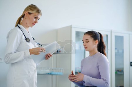 Foto de Mujer joven médico examinando a una adolescente en la ambulancia. - Imagen libre de derechos