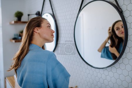 Foto de Mujer joven cuidando el cabello, concepto de rutina de belleza matutina. - Imagen libre de derechos