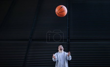 Photo for Young man with down syndrom throwing away a basketball ball. - Royalty Free Image