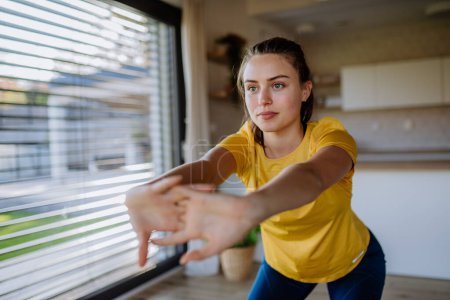 Photo for Young woman doing exercises at home. - Royalty Free Image