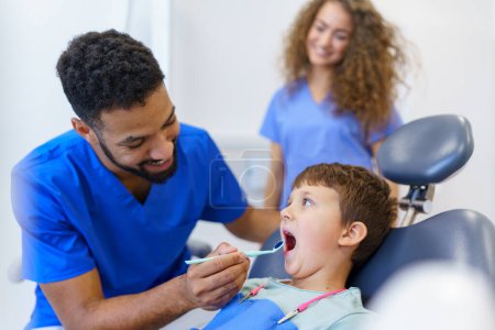Ein kleiner Junge sitzt während der Zahnarztuntersuchung auf dem Zahnarztstuhl.