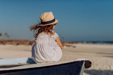 Téléchargez les photos : Vue arrière de la petite fille regardant l'océan. - en image libre de droit