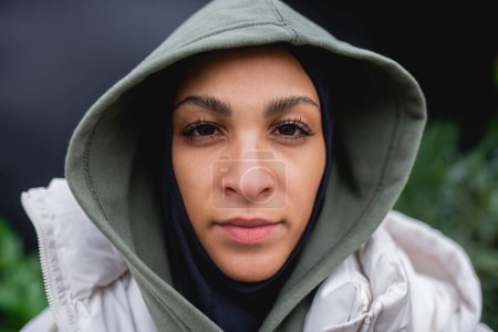Téléchargez les photos : Portrait d'une jeune femme musulmane en plein air, regardant la caméra. - en image libre de droit