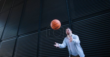 Foto de Joven con síndrome de down tirando una pelota de baloncesto. - Imagen libre de derechos