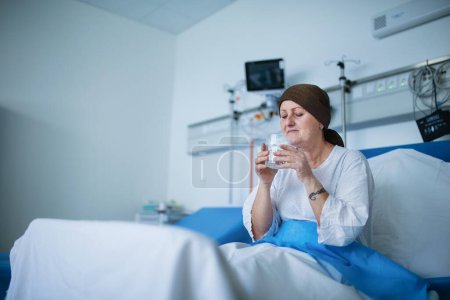 Téléchargez les photos : Femme âgée assise dans la chambre d'hôpital après la chimiothérapie. - en image libre de droit