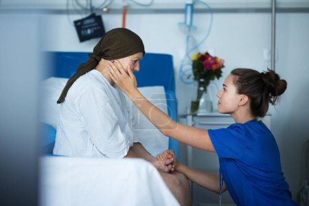 Téléchargez les photos : Infirmière empathique prenant soin d'une femme âgée atteinte d'un cancer, caressant sa joue. - en image libre de droit