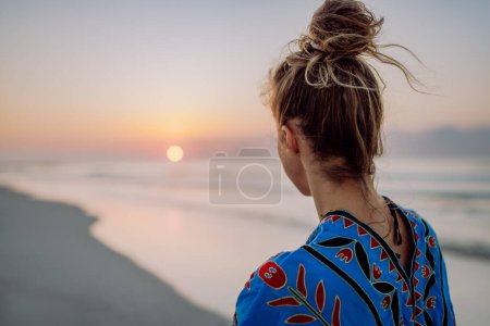 Foto de Vista trasera de la joven mujer disfrutando del tiempo en el océano. - Imagen libre de derechos