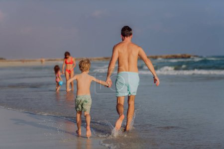Téléchargez les photos : Famille heureuse avec de petits enfants profitant du temps à la mer dans un pays exotique. - en image libre de droit
