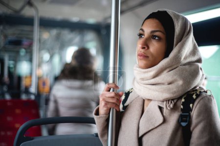 Téléchargez les photos : Jeune femme musulmane voyageant en bus. - en image libre de droit