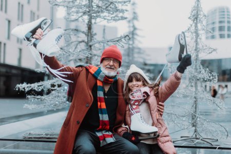 Téléchargez les photos : Portrait de grand-père et petite-fille en hiver sur une patinoire extérieure. - en image libre de droit
