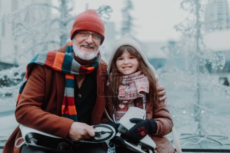 Téléchargez les photos : Portrait de grand-père et petite-fille en hiver sur une patinoire extérieure. - en image libre de droit