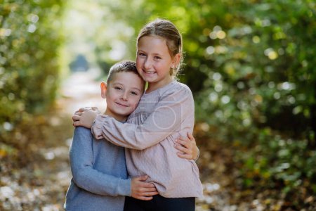 Photo for Portrait of little children, siblings, hugging in a forest. - Royalty Free Image