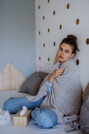 Téléchargez les photos : Femme malade assise dans un lit, ayant un rhume. - en image libre de droit